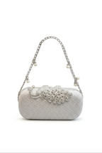 The Pearl Chain Handbag is a silver evening bag with a pearl-adorned chain strap and an ornate, bejeweled peacock design on the front, shown against a plain white background.