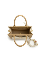 The Beige Bow Shoulder Bag features genuine beige leather, two handles, gold hardware, an open top with a roomy interior and zip pocket, plus a matching detachable shoulder strap with gold clasps, all shown on a white background.